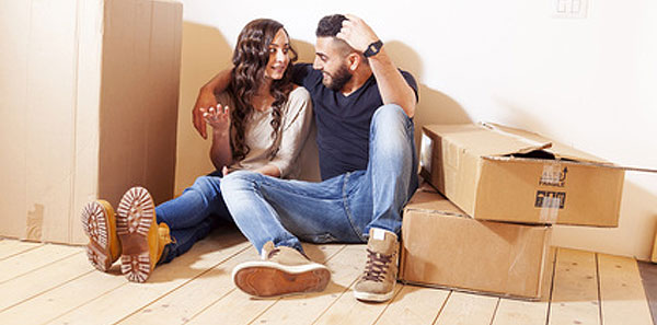 happy couple moving home surrounded by moving boxes